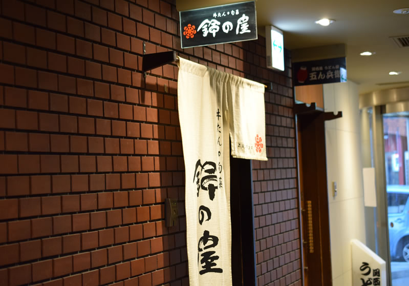 レンガ調の壁に白いのれんが目印